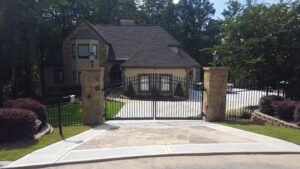 Gated house with stone pillars and driveway.