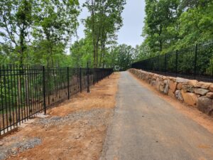 Residential steel fence bodering a long driveway in Cumming Ga., installed by Peachtree Fence & Gates