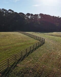 Aerial image of a 4-rail farm fence in an open pasture, installed by Peachtree Fence & Gates