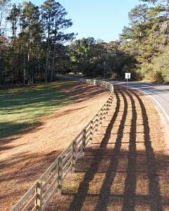 4-rail farm fence curved along the road frontage of a new farm in Ball Ground, Ga., installed by Peachtree Fence & Gates