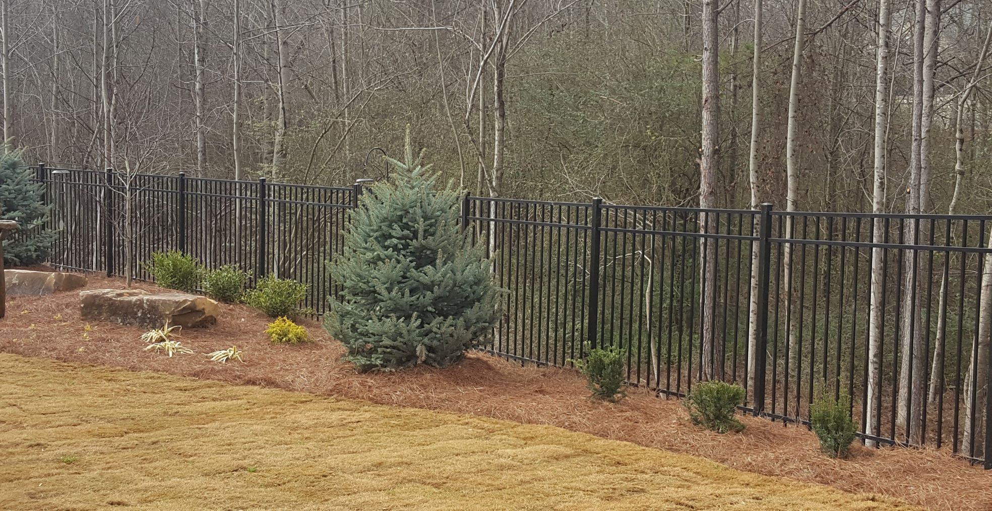 Flat top ornamental aluminum fence installed in a well-manicured backyard in a high-end HOA community in North Georgia.  This was installed by Peachtree Fence & Gates
